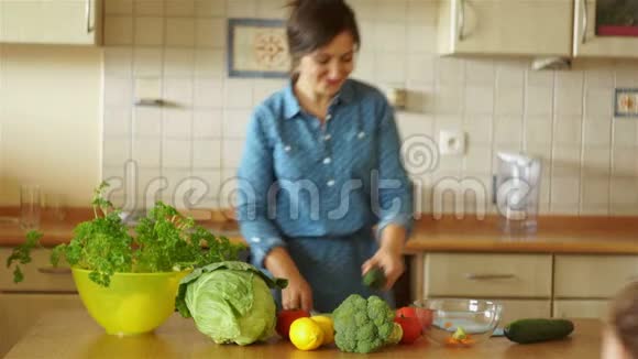一个年轻的燃烧的家庭主妇用黄瓜在厨房里唱歌就像麦克风心情很好星期六的晚餐开玩笑视频的预览图
