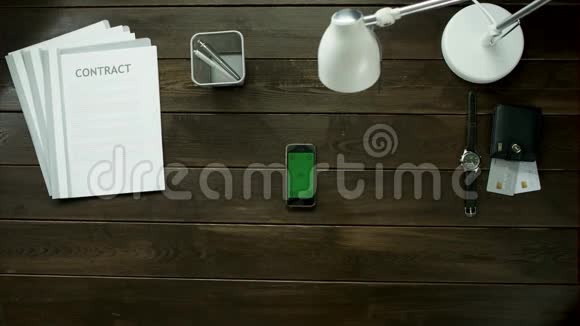 上景一个男人在办公室桌上喝茶用他的手机视频的预览图