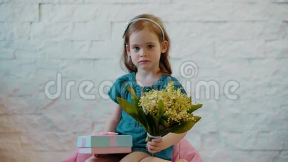 可爱的小女孩展示鲜花和礼物视频的预览图