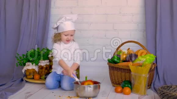 可爱的小女孩厨师用蔬菜和平底锅烹饪健康的食物视频的预览图