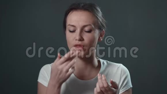 年轻的女人吃快餐孤立的黑色肖像视频的预览图