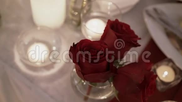 红玫瑰和桌上的蜡烛视频的预览图