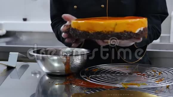 糖果师用巧克力片装饰橙色蛋糕的边缘视频的预览图
