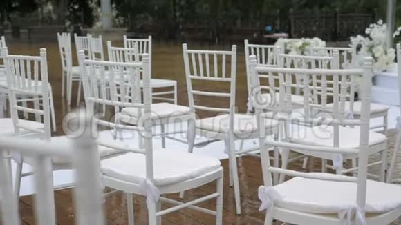 婚礼上白色的折叠椅雨中的水滴露天湿座位视频的预览图