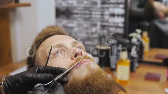 男士美容师理发店照顾胡子一个理发师在胡子和胡子上工作视频的预览图