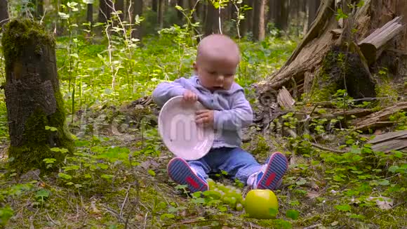 婴儿是婴儿坐在森林里吃森林里的大苹果吃大苹果视频的预览图