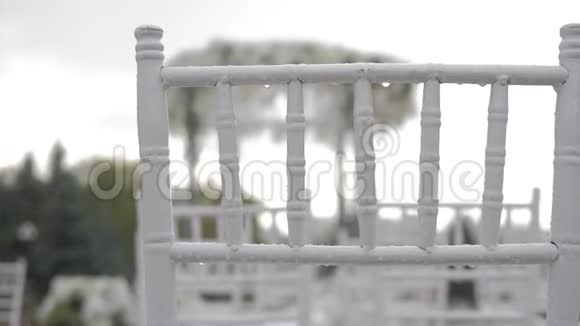 婚礼上白色的折叠椅雨中的水滴露天湿座位视频的预览图