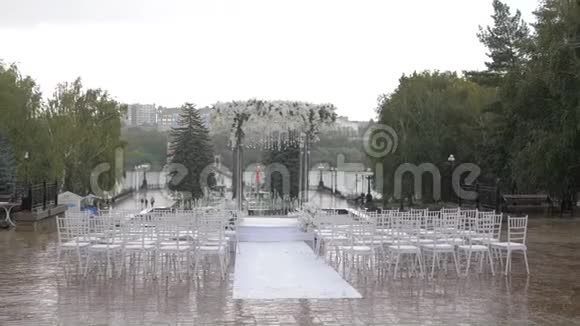 婚礼上白色的折叠椅雨中的水滴露天湿座位视频的预览图