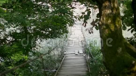 冒险旅行概念悬索桥越过一条山河复制空间视频的预览图