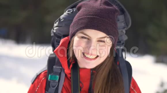 开朗微笑的徒步旅行者摘下帽子旅行者冬季森林中的Hiker正面肖像徒步旅行爱情纯洁视频的预览图