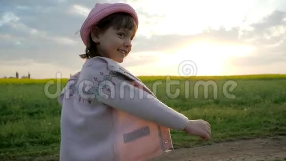 奔跑的女孩微笑的女孩子沿着田野的道路奔跑快乐的孩子在城外快乐健康视频的预览图