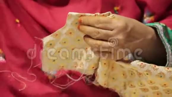 一位身穿五颜六色传统服装的阿拉伯老年妇女缝制当地服装视频的预览图