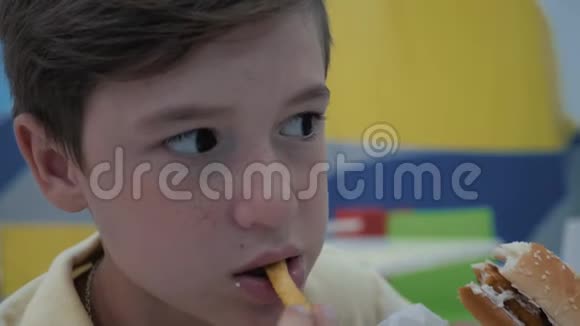 这个男孩在快餐店吃饭有害和可口的食物视频的预览图