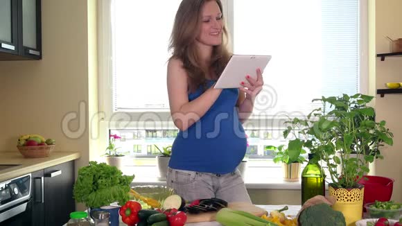 准妈妈用平板电脑准备蔬菜沙拉视频的预览图