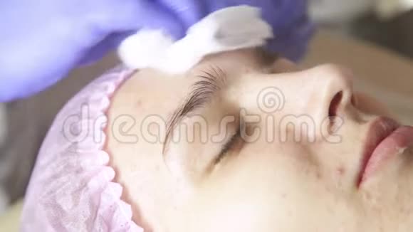 接受水疗治疗的女人用棉签清洗妇女面部视频的预览图