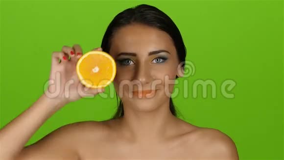 女孩闭上橙色的眼睛微笑并移除橙色绿色屏幕视频的预览图