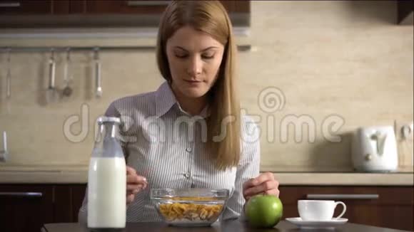 漂亮的年轻漂亮的女商人在厨房吃玉米片作为早餐一杯咖啡视频的预览图