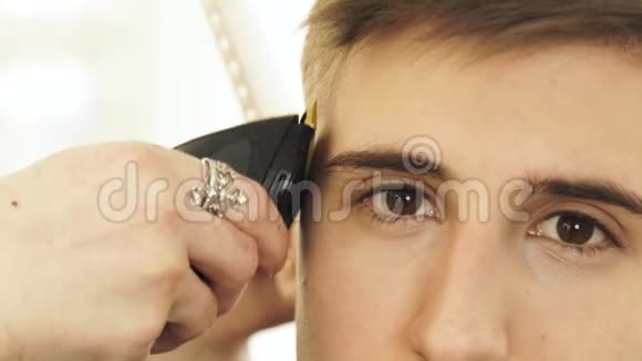 理发店用电动剃须刀理发时要面对英俊的男人用发机将剪毛收口男子视频的预览图