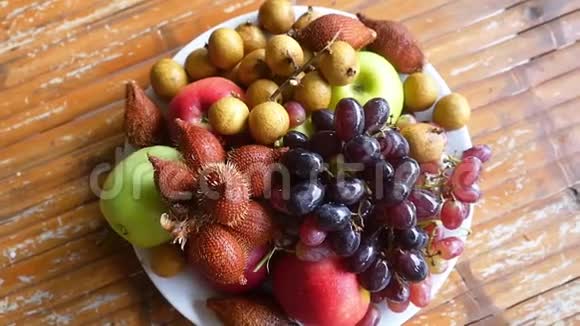 美味可口的热带水果放在木桌上的碗里最高的视野慢动作1920x1080视频的预览图