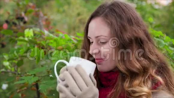 梦想中的女孩正在秋天喝一杯热饮料视频的预览图