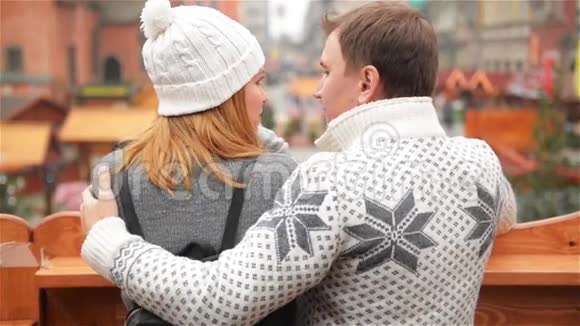圣诞市场背景下快乐男人拥抱微笑女人恋爱中的情侣谈论着一些事情视频的预览图