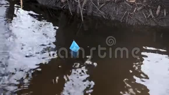 彩纸蓝纸船沿河岸漂浮视频的预览图