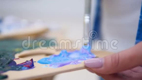 艺术家在调色板上混合颜料视频的预览图
