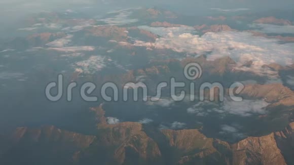 日出时飞越阿尔卑斯山从飞机窗口可以看到空中景色视频的预览图