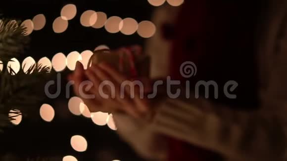 女性手持圣诞礼品盒背景是boke灯光视频的预览图