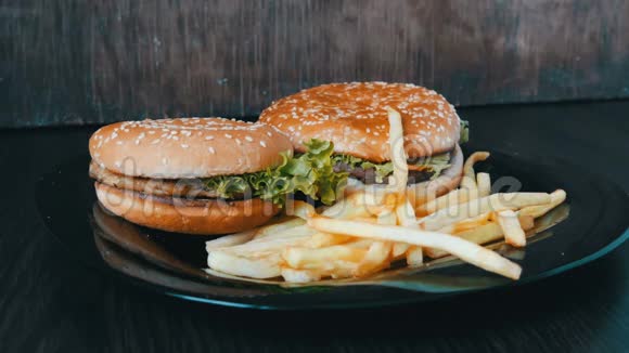 大汉堡与切菜和生菜叶近景炸薯条加汉堡视频的预览图