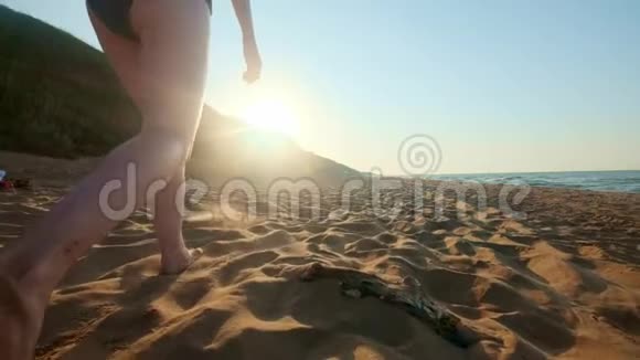 女人在海滩上的湿沙上散步雌足踩着贝壳上的黄沙幸福和自由视频的预览图
