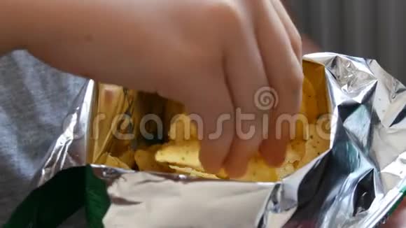 十几岁的男孩吃一包薯片不健康食品快餐视频的预览图