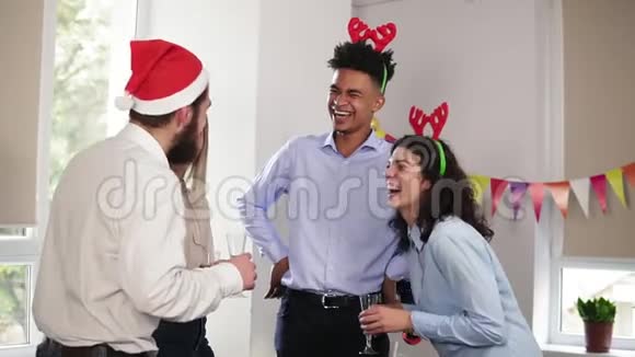 在圣诞晚会上幸福的上班族们举着酒杯端着起泡葡萄酒一边聊天视频的预览图