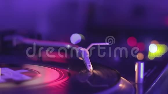 女DJ在调音台播放音乐乙烯基唱片上的Stylus夜总会视频的预览图