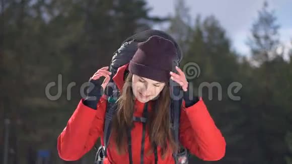 开朗微笑的徒步旅行者摘下帽子旅行者冬季森林中的Hiker正面肖像徒步旅行爱情纯洁视频的预览图
