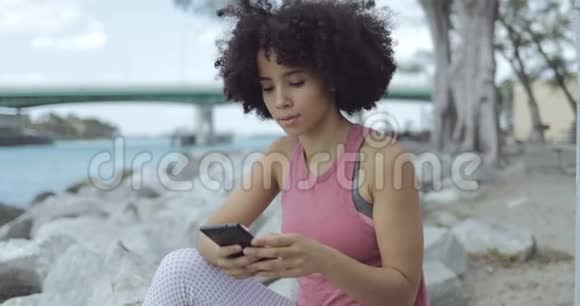 休闲黑人女孩在河边自拍视频的预览图