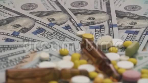 药丸和安瓿旋转的货币医疗成本概念特写镜头相机的焦点是美元视频的预览图