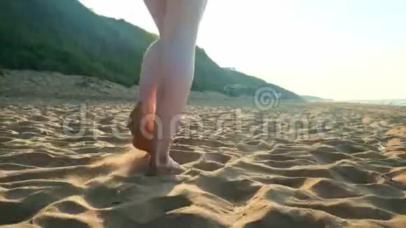 女人在海滩上的湿沙上散步雌足踩着贝壳上的黄沙幸福和自由视频的预览图