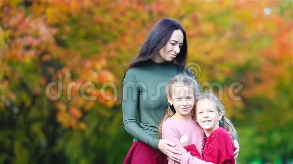 秋天的妈妈和孩子的家人年轻的母亲和小女孩享受温暖的秋天视频的预览图