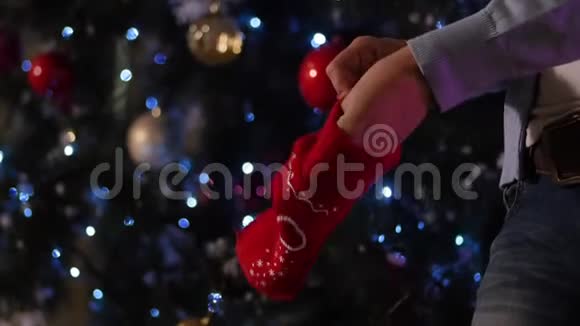 男人穿上红色针织手套在手特写冷杉背景视频的预览图