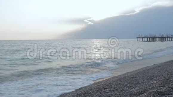 日落时的海上景观码头美丽的地中海海岸滩卵石和海浪视频的预览图