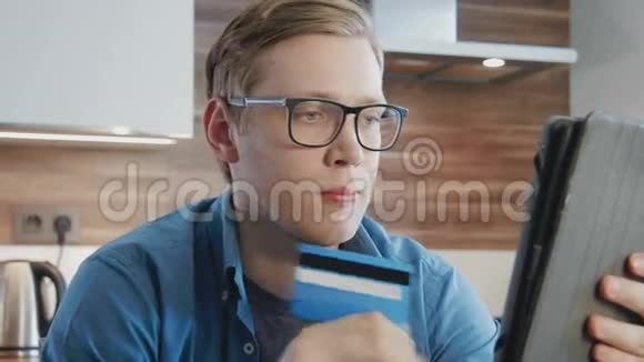 年轻人使用信用卡和数字平板电脑在线购物视频的预览图