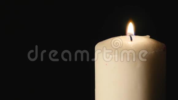 蜡烛吹灭了蜡烛在黑暗中点燃并熄灭白蜡烛黑色背景视频的预览图