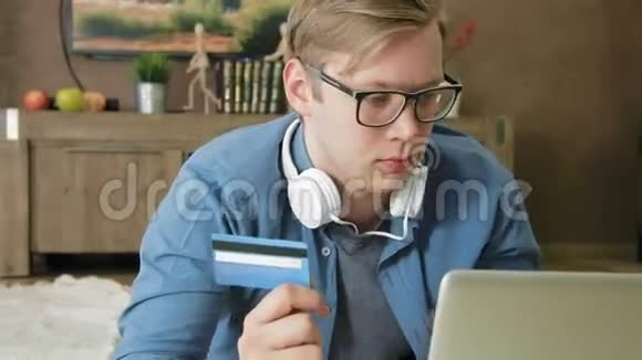 年轻人使用信用卡和笔记本电脑在线购物视频的预览图