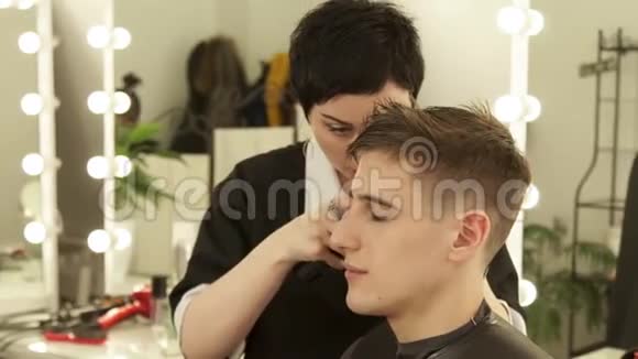 理发店用电动剃须刀理发的理发师将理发器与理发机合拢视频的预览图