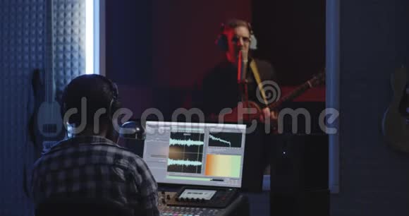 吉他手和音响工程师在工作室工作视频的预览图