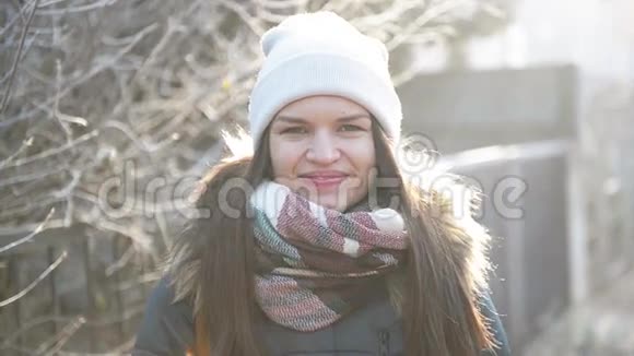 带着迷人微笑的女孩正在她的手上吹气试图在冬天的早晨户外温暖自己笑的女人视频的预览图