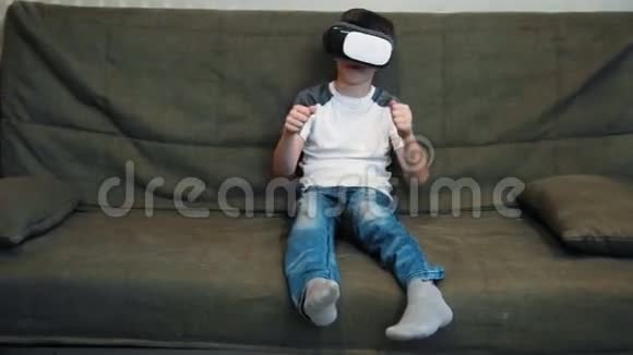 坐在沙发上的小男孩用虚拟现实耳机进行调色游戏视频的预览图