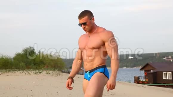 海滩上的健美运动员展示肌肉发达的身体视频的预览图