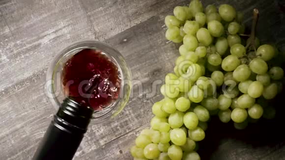 慢动作将瓶子中的葡萄酒倒入玻璃杯中开胃菜的顶部景观视频的预览图
